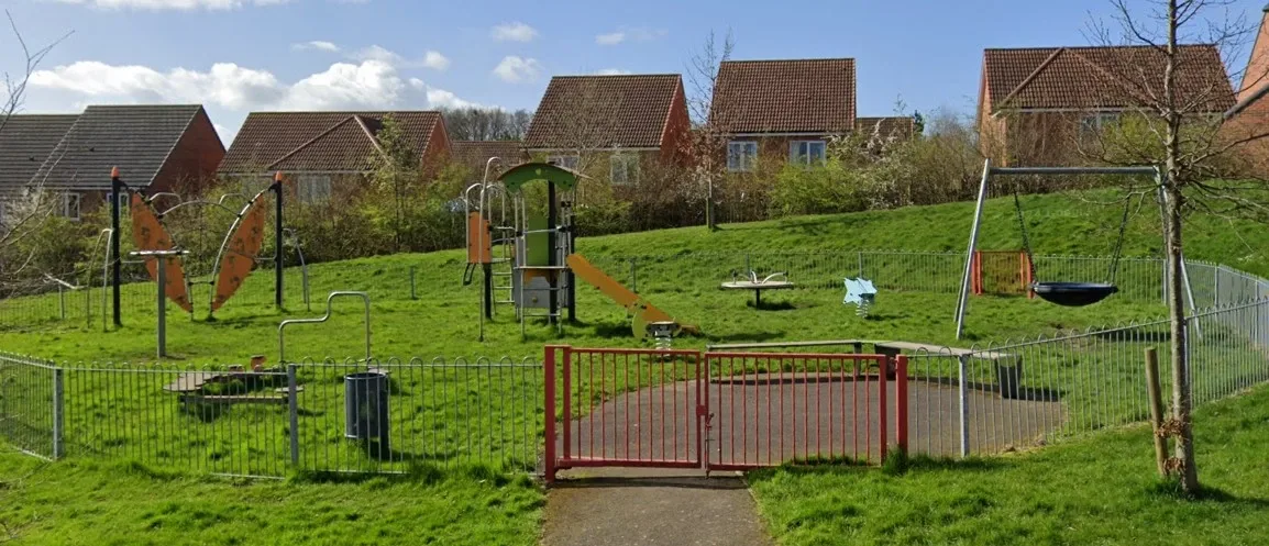 Oak Crescent Playground with play equipment on a grassy hill