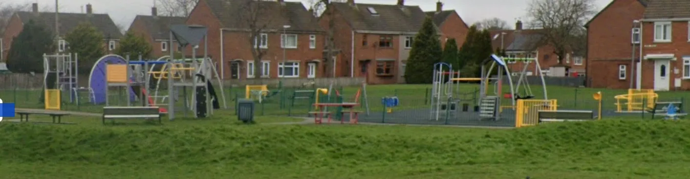 The Pentlands Playground with open grassy surroundings and play equipment